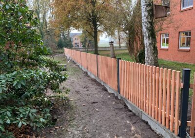 Lärchen Staketenzaun mit Stahlpfosten und Betonbordstein