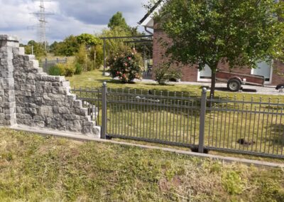 Schmiedezaun anschließend an Natursteinmauer